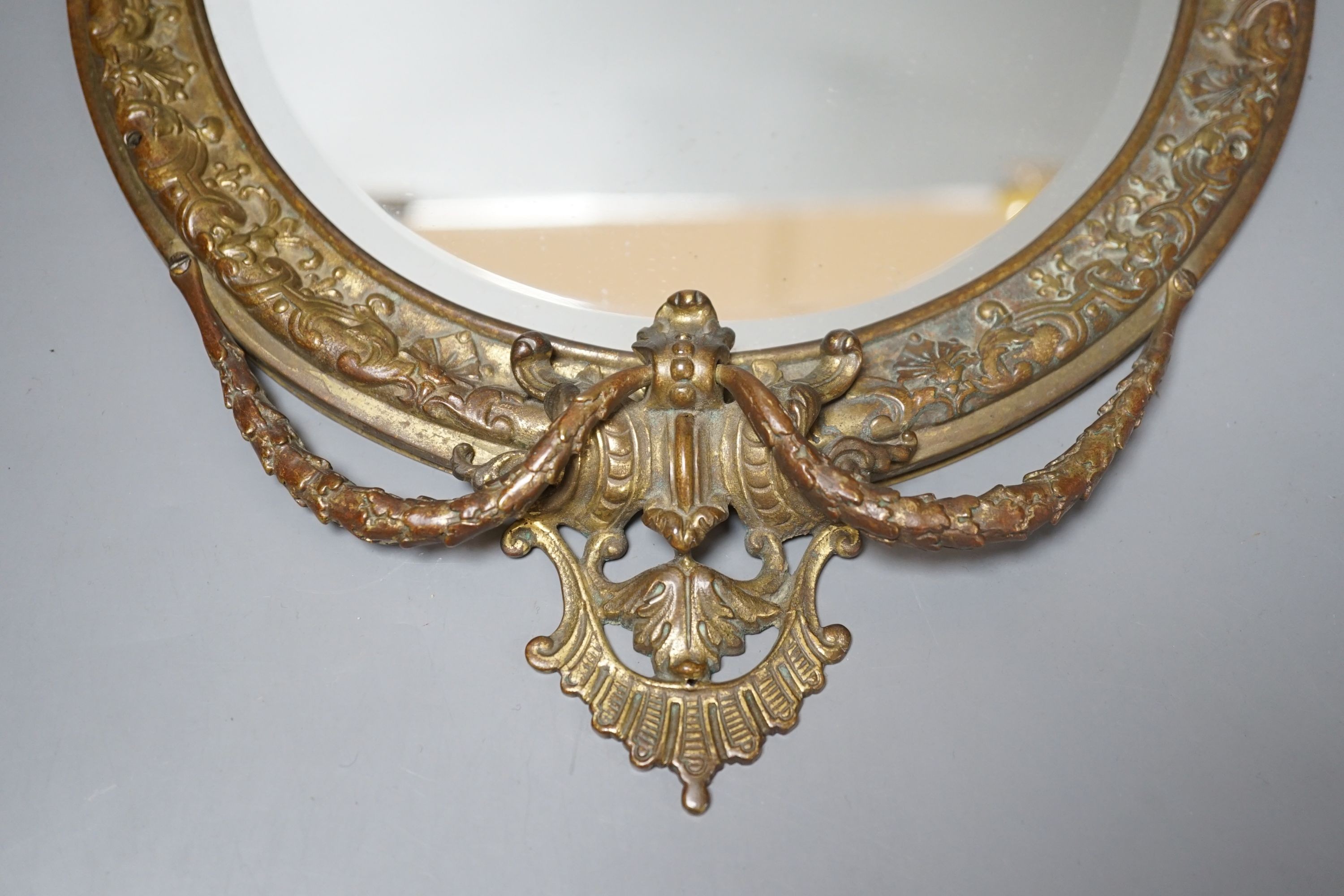 An early 20th century decorative gilt metal mirror, 41 cms high